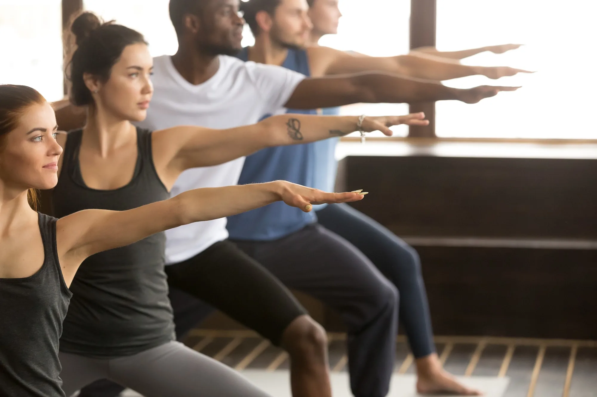 Pilates class stretching their arms forward in unison